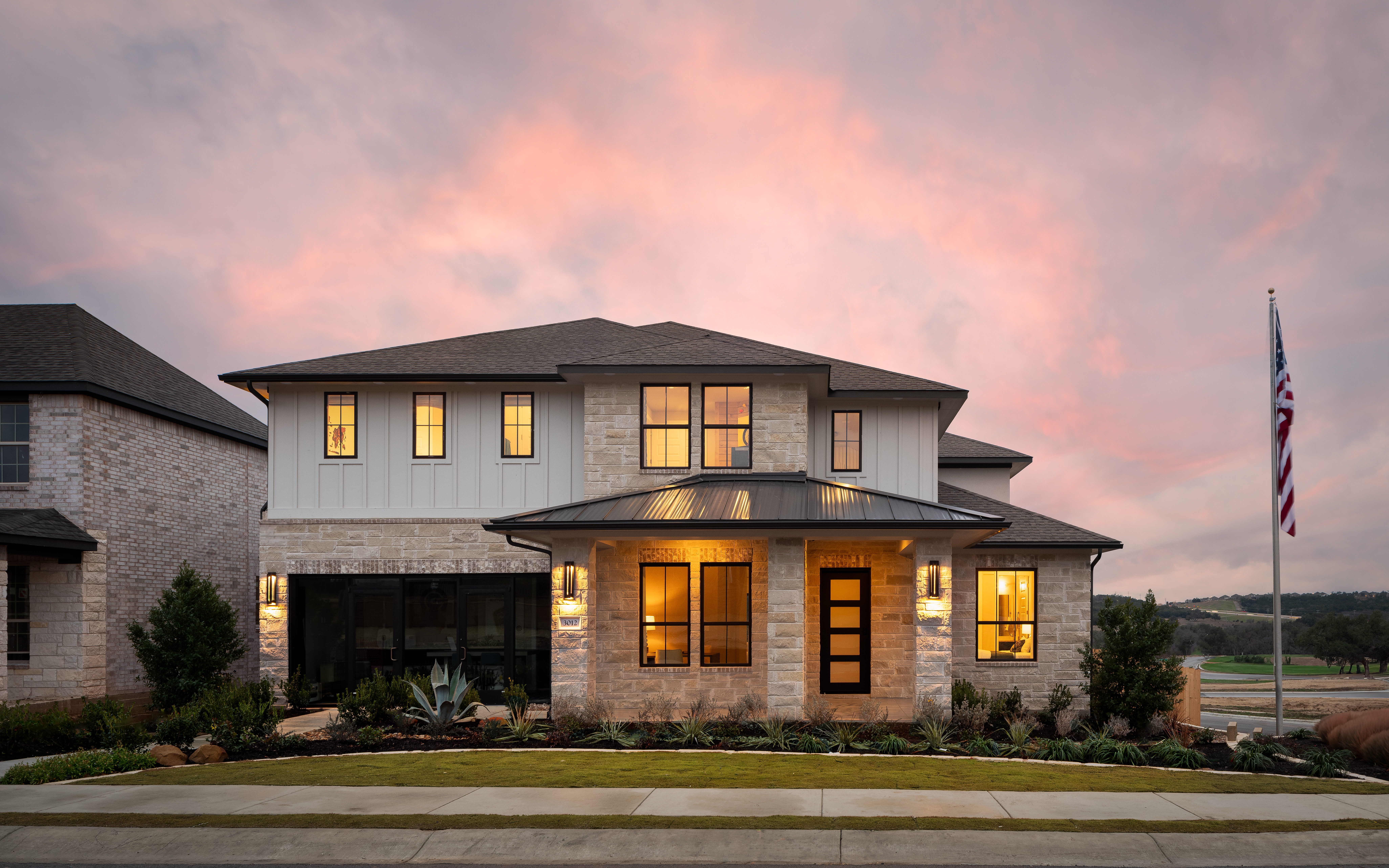 Photo of GFO's Model Home in the new home community Bluffview Reserve in Leander. It our Harrison floor plan, and a sunset exterior shot of the gorgeous luxury home